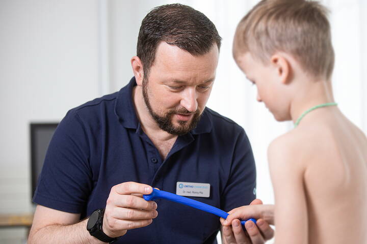 Dr. Ronny Pilz im Gespräch mit einem jungen Patienten, Ortho Cham Zug